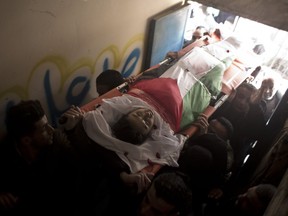Palestinian mourners carry the lifeless body of Hassan Shalabi, 14, into the family home during his funeral in Nuseirat refugee camp, central Gaza Strip, Saturday, Feb. 9, 2019.  Israeli troops shot and killed two Palestinian teenagers Friday as thousands held demonstrations along the perimeter fence separating Gaza and Israel.