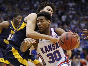 Kansas guard Ochai Agbaji (30) attempts to get past West Virginia guard Jermaine Haley (10)during the first half of an NCAA college basketball game, Saturday, Feb. 16, 2019, in Lawrence, Kan.