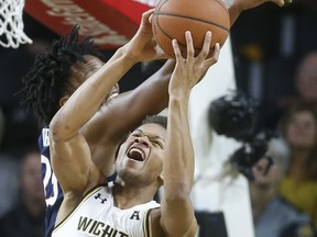 Wichita State guard Dexter Dennis fights for a rebound against Connecticut forward Josh Carlton during the first half of an NCAA college basketball game in Wichita, Kan., Thursday, Feb. 28, 2019.