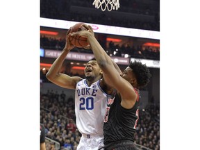 Louisville center Steven Enoch (23) attempts to block the shot of Duke center Marques Bolden (20) during the first half of an NCAA college basketball game in Louisville, Ky., Tuesday, Feb. 12, 2019.