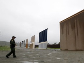 FILE - In this Feb. 5, 2019 file photo a Border Patrol agent walks towards prototypes for a border wall in San Diego. The Trump administration on Wednesday, Feb. 27 plans to demolish eight prototypes of the president's prized border wall that the government built near San Diego one year ago.