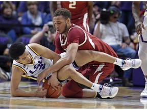 LSU guard Tremont Waters (3) and Arkansas forward Daniel Gafford (10) scramble for the ball during the first half of an NCAA college basketball game Saturday, Feb. 2, 2019, in Baton Rouge, La.