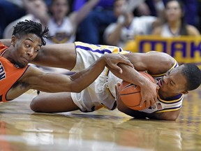 LSU guard Ja'vonte Smart, right, hits the floor going for a loose ball along with Auburn forward Anfernee McLemore, left, in the first half of an NCAA college basketball game, Saturday, Feb. 9, 2019, in Baton Rouge, La.