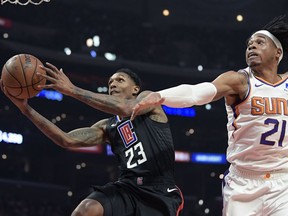 Los Angeles Clippers guard Lou Williams, left, shoots as Phoenix Suns forward Richaun Holmes defends during the first half of an NBA basketball game Wednesday, Feb. 13, 2019, in Los Angeles.