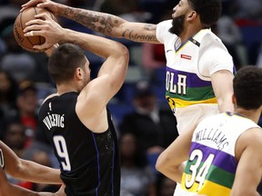 Orlando Magic center Nikola Vucevic (9) is blocked by New Orleans Pelicans forward Anthony Davis (23) during the first half of an NBA basketball game in New Orleans, Tuesday, Feb. 12, 2019.
