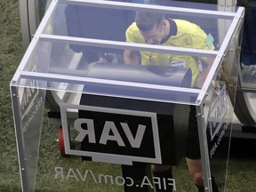 FILE - In this Friday, June 22, 2018 file photo, referee Matt Conger from New Zealand watches the Video Assistant Referee system, known as VAR during the group D match between Nigeria and Iceland at the 2018 soccer World Cup in the Volgograd Arena in Volgograd, Russia. Women's World Cup referees are undergoing training with VARs over the next two weeks, The Associated Press has learned, paving the way for the FIFA Council to approve the use of video reviews at this year's tournament in France.