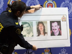 An OPP officer adjusts a poster showing at Kingston police headquarters that shows three cold case victims Henrietta Knight, Richard Kimball and Stephen St. Denis at a press conference in Kingston, Ont. on Friday Feb. 15, 2019. Police in eastern Ontario say they have solved three cold case homicides in Kingston, Ont. Ontario Provincial Police and Kingston police allege a 65-year-old man murdered one woman and two men between 1995 and 2001.
