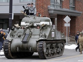 World War II tank gunner Clarence Smoyer waves from his perch seated on the hatch of a tank outside the Charlestown Naval Shipyard in Boston, Wednesday, Feb. 20, 2019. The 95-year-old veteran was surprised with a ride through the streets of Boston in a Sherman tank, one of the tanks most widely used by the U.S. during the war.