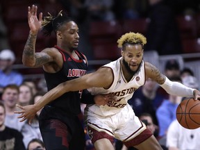 Louisville guard Khwan Fore, left, tries to hold back Boston College guard Ky Bowman, right, during the first half of an NCAA college basketball game in Boston, Wednesday, Feb. 27, 2019.