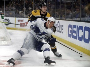 Boston Bruins defenseman Torey Krug (47) and Tampa Bay Lightning left wing Ondrej Palat (18) compete for the puck during the first period of an NHL hockey game Thursday, Feb. 28, 2019, in Boston.