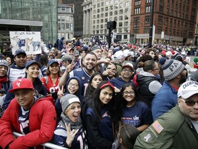 Fans gather near Boston City Hall, Tuesday, Feb. 5, 2019, to watch the New England Patriots football team victory parade through the streets of Boston to celebrate their win over the Los Angeles Rams for their sixth NFL Super Bowl championship.
