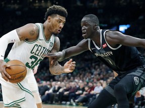 Boston Celtics' Marcus Smart, left, drives for the basket against Detroit Pistons' Thon Maker, right, during the first half of an NBA basketball game in Boston, Wednesday, Feb. 13, 2019.