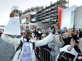 New England Patriots cornerback Jason McCourty, left, holds the Super Bowl trophy as he greets fans following the football team's arrival at Gillette Stadium, Monday, Feb. 4, 2019, in Foxborough, Mass, after defeating the Los Angeles Rams Sunday in NFL Super Bowl 53, in Atlanta, Ga.