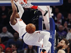 New York Knicks guard Dennis Smith Jr. dunks as Detroit Pistons forward Blake Griffin watches during the first half of an NBA basketball game Friday, Feb. 8, 2019, in Detroit.