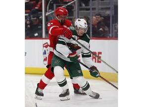 Detroit Red Wings center Frans Nielsen (51) checks Minnesota Wild right wing Mikael Granlund (64) during the second period of an NHL hockey game Friday, Feb. 22, 2019, in Detroit.