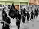 This undated file image posted on a militant website on Tuesday, Jan. 14, 2014 shows ISIL fighters marching in Raqqa, Syria. 