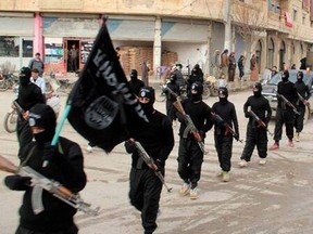 This undated file image posted on a militant website on Tuesday, Jan. 14, 2014 shows ISIL fighters marching in Raqqa, Syria.