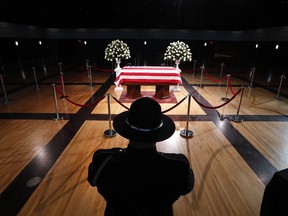 A police officer stands guard stands guard at the casket of former Michigan Rep. John Dingell, lying in repose in Dearborn, Mich., Monday, Feb. 11, 2019. Dingell, the longest-serving member of Congress in American history, was first elected in 1955 and retired in 2014. The Democrat was 92.