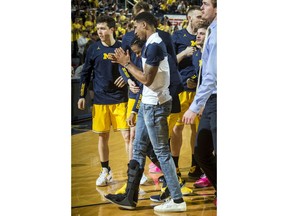 Michigan guard Charles Matthews, center, walks with a right foot cast, before an NCAA college basketball game against Nebraska at Crisler Center in Ann Arbor, Mich., Thursday, Feb. 28, 2019. Matthews injured his right foot during Michigan's loss to Michigan State last Sunday.