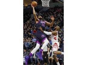 Minnesota Timberwolves' Karl-Anthony Towns, left, goes in for a layup as Houston Rockets' Chris Paul defends in the first half of an NBA basketball game, Wednesday, Feb. 13, 2019, in Minneapolis.