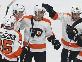 Philadelphia Flyers' Ivan Provorov, center, of Russia, gets a congratulatory tap on the helmet from Phil Varone after his goal off Minnesota Wild goalie Devan Dubnyk in the first period of an NHL hockey game, Tuesday, Feb. 12, 2019, in St. Paul, Minn.