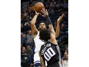 Minnesota Timberwolves' Karl-Anthony Towns, left, shoots over Sacramento Kings' Willie Cauley-Stein in the first half of an NBA basketball game Monday, Feb. 25, 2019, in Minneapolis.
