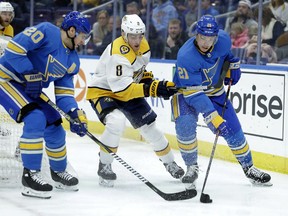 St. Louis Blues' Tyler Bozak (21) and Nashville Predators' Kyle Turris (8) chase after a loose puck as the Blues' Alexander Steen (20) watches during the second period of an NHL hockey game Saturday, Feb. 9, 2019, in St. Louis.