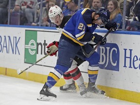 St. Louis Blues' Tyler Bozak (21) battles New Jersey Devils' Joey Anderson (49) along the boards in the first period of an NHL hockey game, Tuesday, Feb. 12, 2019, in St. Louis.