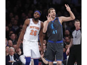 Dallas Mavericks forward Dirk Nowitzki (41) signals to his bench with New York Knicks center Mitchell Robinson (26) awaiting the an official's call during the first half of an NBA basketball game, Wednesday, Jan. 30, 2019, in New York.