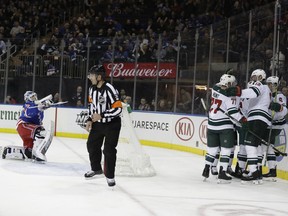 New York Rangers goaltender Henrik Lundqvist, left, gets up as the Minnesota Wild celebrate a goal by Jared Spurgeon during the first period of an NHL hockey game Thursday, Feb. 21, 2019, in New York.