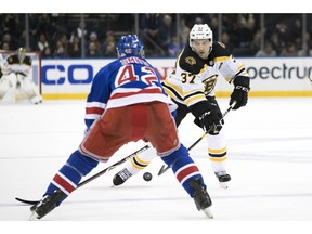 Boston Bruins center Patrice Bergeron (37) skates against New York Rangers defenseman Brendan Smith (42) in the first period of an NHL hockey game, Wednesday, Feb. 6, 2019, at Madison Square Garden in New York.