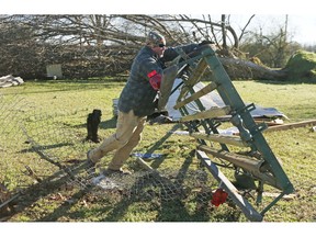 Jack Gordman flips over a boat trailer that was tossed several feef from his parent's home in Columbus, Miss., Sunday morning, Feb. 24, 2019, after Saturday's tornado that killed at least one person and shattered businesses and several homes.