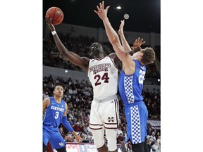 Mississippi State forward Abdul Ado (24) pushes back against Kentucky forward Reid Travis (22) as he goes for a layup during the first half of an NCAA basketball game in Starkville, Miss., Saturday, Feb. 9, 2019.