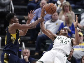 Indiana Pacers forward Thaddeus Young (21) fouls Milwaukee Bucks guard Pat Connaughton (24) during the first half of an NBA basketball game in Indianapolis, Wednesday, Feb. 13, 2019.