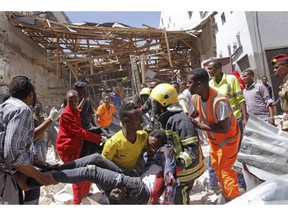 Rescuers carry away a man who was severely injured by a blast in the capital Mogadishu, Somalia, Monday, Feb. 4, 2019.  A Somali police officer says a number of people died in a powerful car bomb explosion near a mall close to local government offices in Somalia's capital Monday.