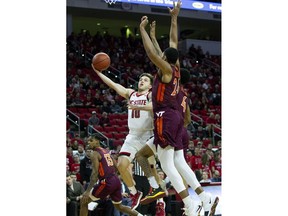 North Carolina State's Braxton Beverly (10) attempts a shot over Virginia Tech's Kerry Blackshear Jr. (24) and Virginia Tech's Nickeil Alexander-Walker (4) during the first half of an NCAA college basketball game in Raleigh, N.C., Saturday, Feb. 2, 2019.