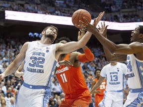 North Carolina's Luke Maye (32) and Kenny Williams (24), and Syracuse's Oshae Brissett (11) battle for a rebound during the first half of an NCAA college basketball game in Chapel Hill, N.C., Tuesday, Feb. 26, 2019.