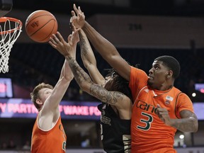 Wake Forest's Sharone Wright Jr., center, tries to shoot between Miami's Anthony Lawrence II, right, and Sam Waardenburg, left, during the first half of an NCAA college basketball game in Winston-Salem N.C., Tuesday, Feb. 26, 2019.