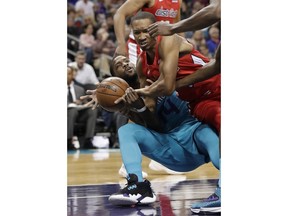 Charlotte Hornets forward Michael Kidd-Gilchrist, left, and Washington Wizards forward Wesley Johnson, right, battle for the ball during the first half of an NBA basketball game in Charlotte, N.C., Friday, Feb. 22, 2019.
