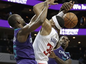 Los Angeles Clippers' Tobias Harris (34) is fouled as he drives between Charlotte Hornets' Kemba Walker, left, and Marvin Williams, right, during the second half of an NBA basketball game in Charlotte, N.C., Tuesday, Feb. 5, 2019.
