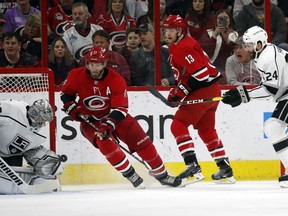 Carolina Hurricanes' Jordan Staal (11) and Warren Foegele (13) watch as Los Angeles Kings goalie Jonathan Quick (32) reaches for the puck during the first period of an NHL hockey game in Raleigh, N.C., Tuesday, Feb. 26, 2019.