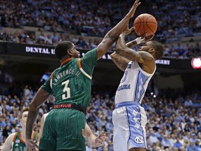 North Carolina's Seventh Woods (0) shoots while Miami's Anthony Lawrence II (3) defends during the first half of an NCAA college basketball game in Chapel Hill, N.C., Saturday, Feb. 9, 2019.