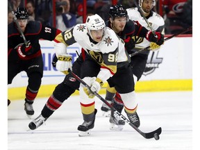 Vegas Golden Knights' Tomas Nosek (92) sakes with the puck after taking it from Carolina Hurricanes' Brett Pesce (22) during the first period of an NHL hockey game Friday, Feb. 1, 2019, in Raleigh, N.C.