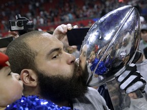 New England Patriots' Lawrence Guy kisses the trophy after the NFL Super Bowl 53 football game against the Los Angeles Rams, Sunday, Feb. 3, 2019, in Atlanta. The Patriots won 13-3.