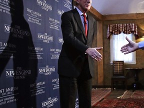 Former Massachusetts Gov. William Weld, wearing work boots with a suit, reaches out to shake hands during a New England Council 'Politics & Eggs' breakfast in Bedford, N.H., Friday, Feb. 15, 2019. The political breakfast is a common stop for candidates considering presidential bids.