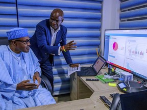 In this photo released by the Nigeria State House, Nigeria Incumbent President Muhammadu Buhari, left, listen to Director of Election Planning and Monitoring Babatunde Raji Fashola, right, as he explain the progress of the party election results in Abuja, Nigeria Monday, Feb. 25, 2019. Nigeria's electoral commission on Monday began announcing official results from the country's 36 states as President Muhammadu Buhari seeks a second term.