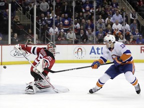 New York Islanders center Mathew Barzal (13) scores a goal on New Jersey Devils goaltender Cory Schneider (35) during the first period of an NHL hockey game Thursday, Feb. 7, 2019, in Newark, N.J.
