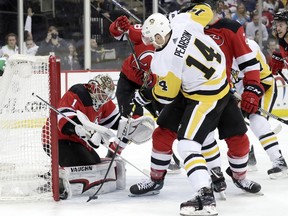 New Jersey Devils goaltender Keith Kinkaid (1) stops a shot s Pittsburgh Penguins left wing Tanner Pearson (14) attacks during the first period of an NHL hockey game, Tuesday, Feb. 19, 2019, in Newark, N.J.