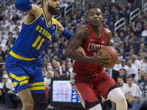 UNLV guard Amauri Hardy (3) drives the baseline against Nevada forward Cody Martin (11) during the first half of an NCAA college basketball game in Reno, Nev., Wednesday, Feb. 27, 2019.