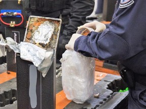 This photo provided by U.S. Customs and Border Protection shows an officer extracting methamphetamine from a loudspeaker on Jan. 11, 2019 at the Los Angeles-Long Beach seaport.  Australian police arrested six people after what authorities said Friday, Feb. 8, 2019  was the largest single seizure of methamphetamine in the United States and the biggest drug haul bound for Australia. U.S. Customs and Border Protection said 1,728 kilograms (3,800 pounds) of the drug were seized mid-January at the Los Angeles-Long Beach port complex along with smaller amounts of cocaine and heroin.  (U.S. Customs and Border Protection via AP)